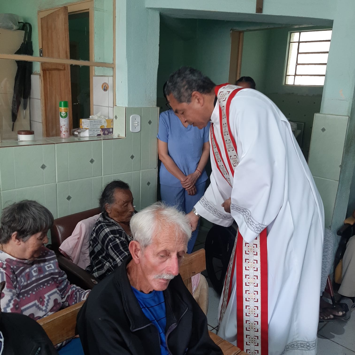 Padre Amauri abençoando idosos